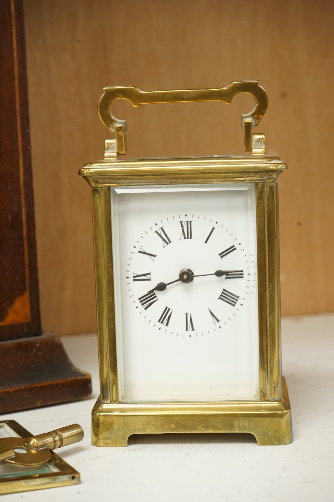 An early 20th century inlaid mantel clock with key and pendulum and a brass cased carriage timepiece, largest 32cm high